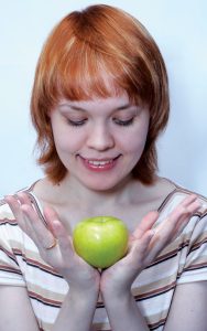 red haired girl with green apple