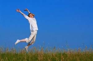 beauty girl jumping in field under blue sky